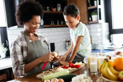 Mother and child having fun preparing healthy food in kitchen